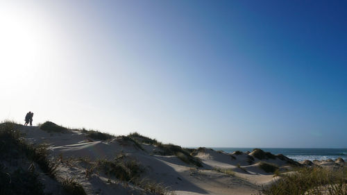 Scenic view of beach against clear blue sky