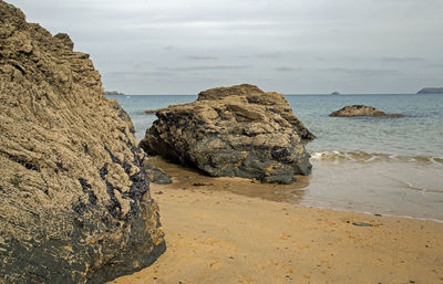 Rocks on beach against sky