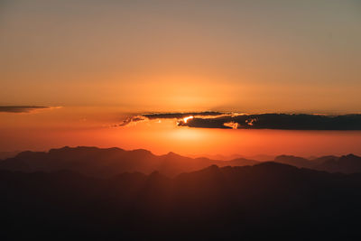 Scenic view of silhouette mountains against romantic sky at sunset