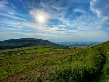 Scenic view of sun shining over a valley 