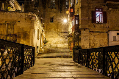 Street amidst buildings at night