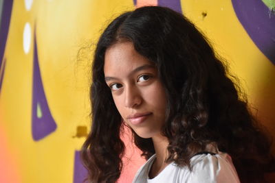 Close-up portrait of girl against wall