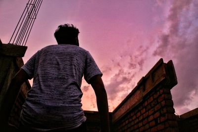 Rear view of man looking at sunset