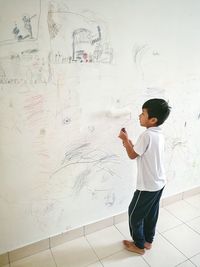 Full length of boy standing against wall