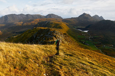 Rear view of man on mountain against sky