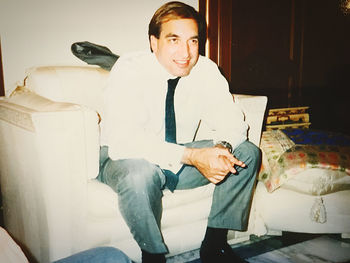 Young man sitting on sofa at home