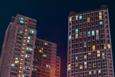 Low angle view of illuminated buildings against sky at night