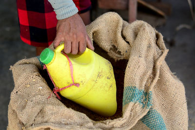 Midsection of man holding bottle