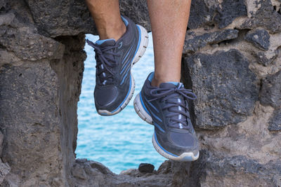 Low section of man standing on rock