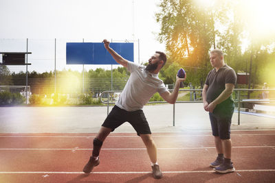 Men participating in sports competition on athletics track