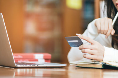 Midsection of man using mobile phone on table