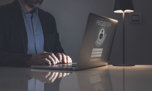 Midsection of businessman using mobile phone while standing in office