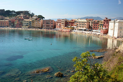Buildings by sea against sky