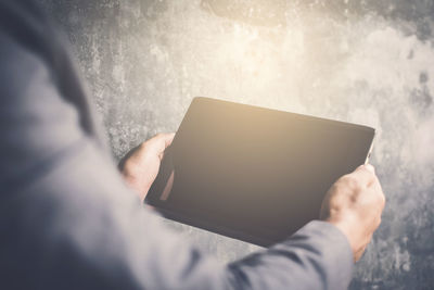 Midsection of man using mobile phone