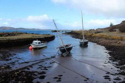 Boats in sea with mountain in background