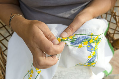 Midsection of woman embroidering on fabric