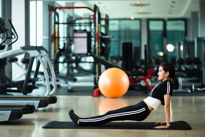 Side view of girl exercising at gym