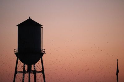 Low angle view of water tower against sky during sunset