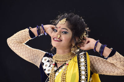 Portrait of a smiling young woman over black background