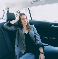 Portrait of beautiful woman sitting in car