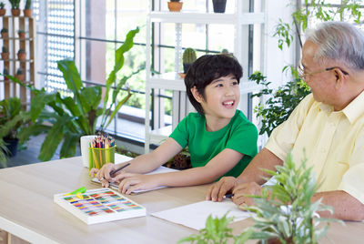 Happy friends sitting on table