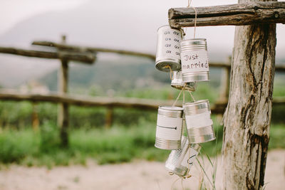 Close-up of can hanging on wood outdoors