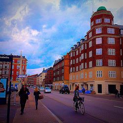 Buildings in city against cloudy sky