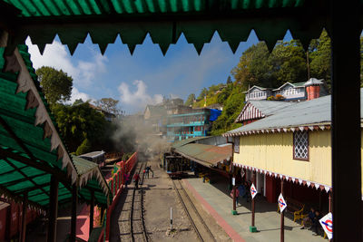 Panoramic view of railroad tracks amidst buildings against sky