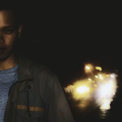 Portrait of young man standing at night