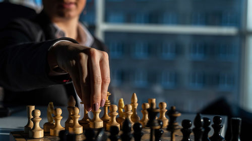 Midsection of man playing on chess board