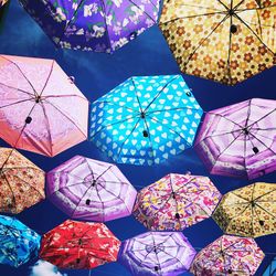 Low angle view of multi colored umbrellas hanging at market stall