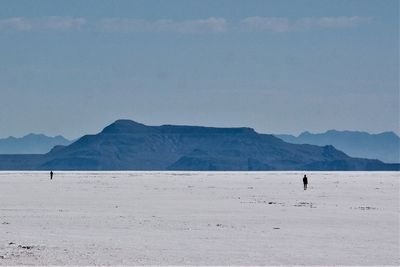 Scenic view of sea and mountains against sky