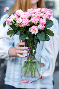 Midsection of woman holding rose bouquet