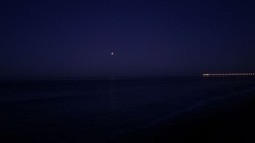 Scenic view of sea against clear sky at night