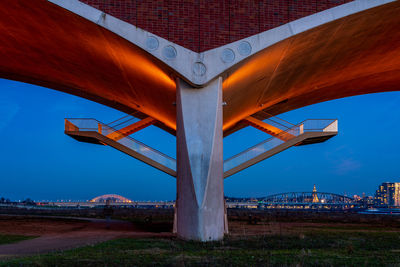 The de oversteek bridge in the dutch city of nijmegen is illuminated in the evening.