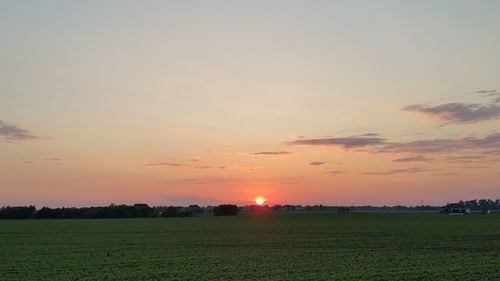 Scenic view of field against sky during sunset