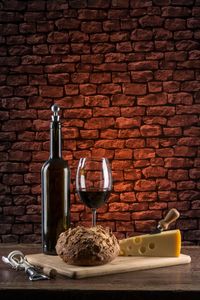 Close-up of wine bottle against brick wall