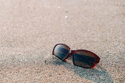 Close-up of sunglasses on sand