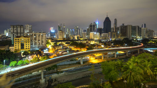 Illuminated modern buildings in city against sky