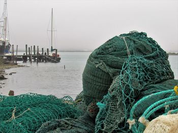 Fishing boats moored at harbor against clear sky