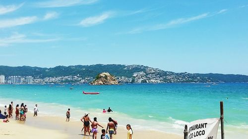 People on beach against blue sky