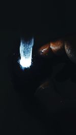 Close-up of human hand against black background