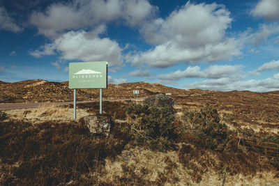 Information sign on landscape against sky