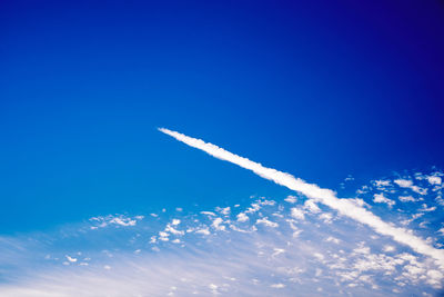 Low angle view of airplane flying against blue sky