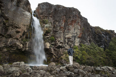 Full length of man looking at waterfall