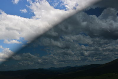 Scenic view of mountains against cloudy sky