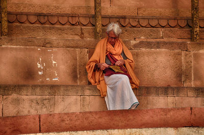 Full length of man sitting on staircase