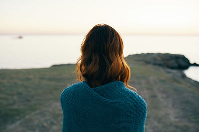 Rear view of woman looking at sea against sky