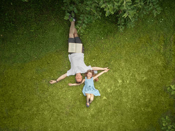Full length of happy young woman lying on grass