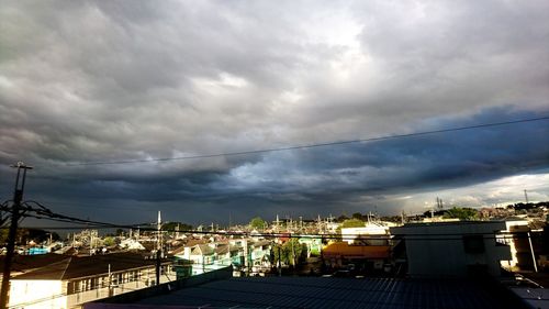 View of cityscape against cloudy sky